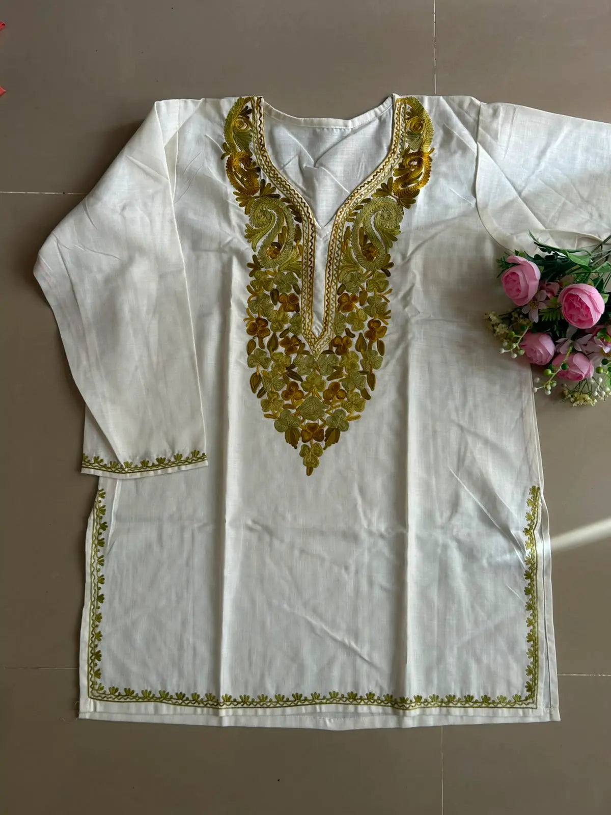 
White cotton Kashmiri short embroidered kurti featuring intricate traditional Kashmiri embroidery and soft breathable cotton fabric for timeless and elegant everyday ethnic wear by Hayat's Lucknowi.
