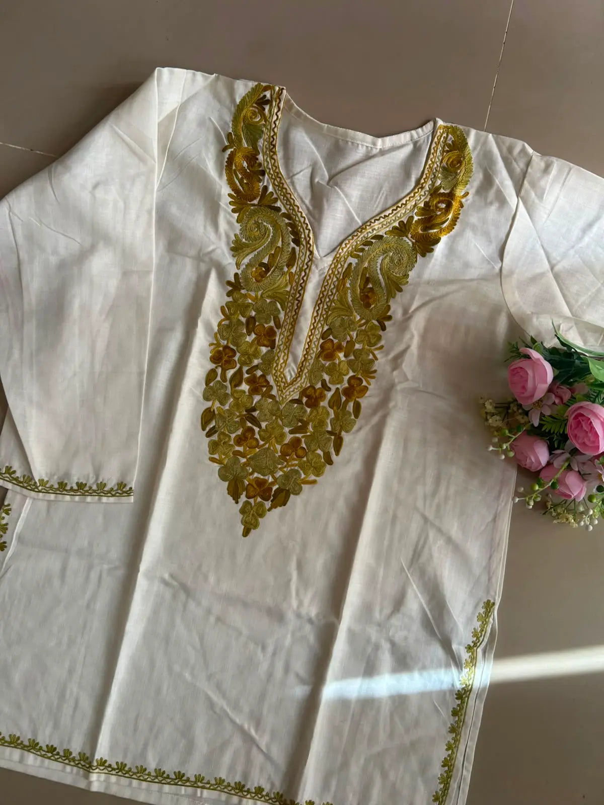 
White cotton Kashmiri short embroidered kurti featuring intricate traditional Kashmiri embroidery and soft breathable cotton fabric for timeless and elegant everyday ethnic wear by Hayat's Lucknowi.
